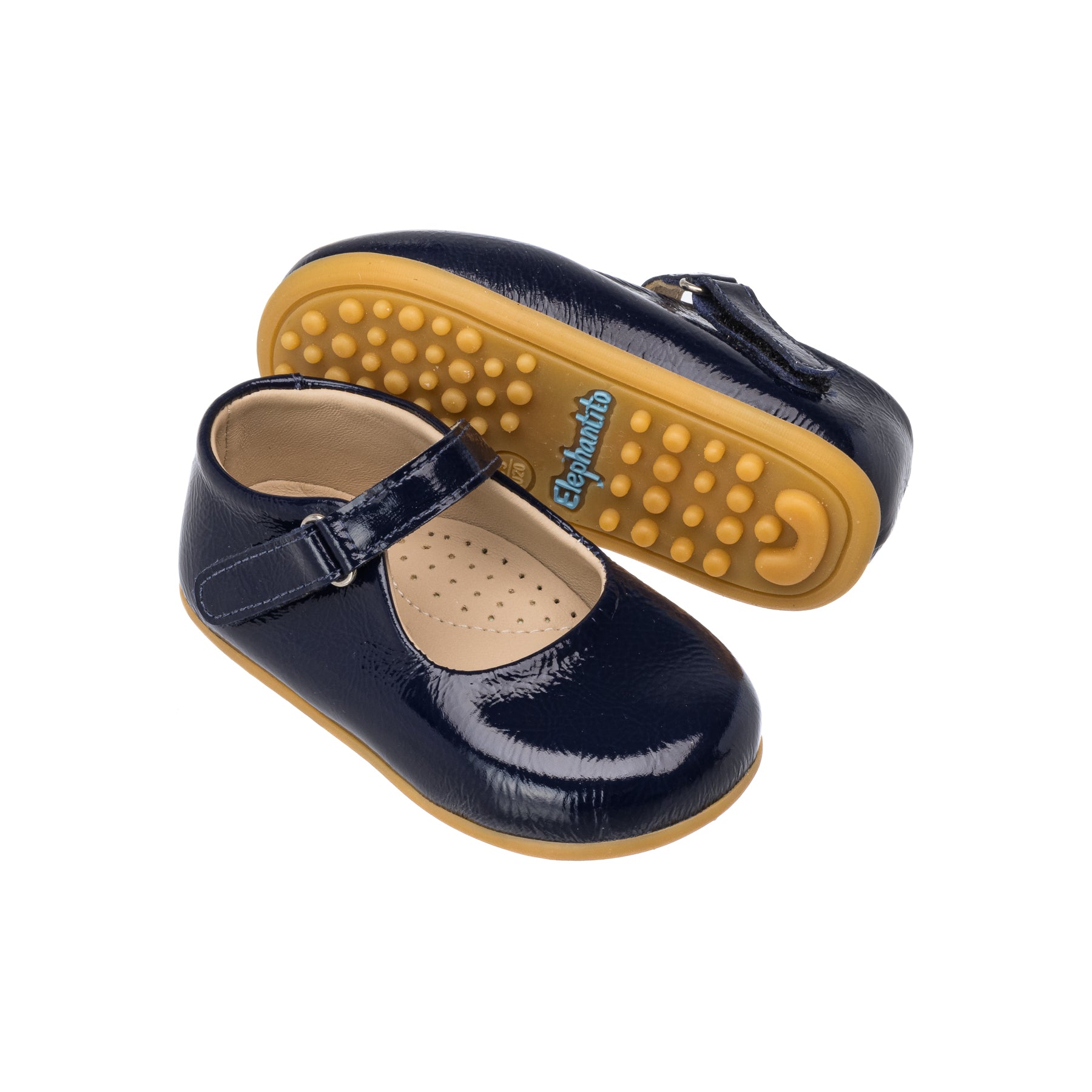 Glossy navy blue toddler Mary Jane shoes with adjustable buckle and textured tan sole.