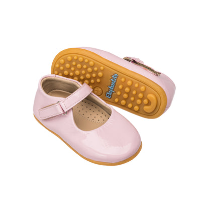 Toddler pink patent leather Mary Jane shoes with adjustable buckle strap and textured rubber soles.