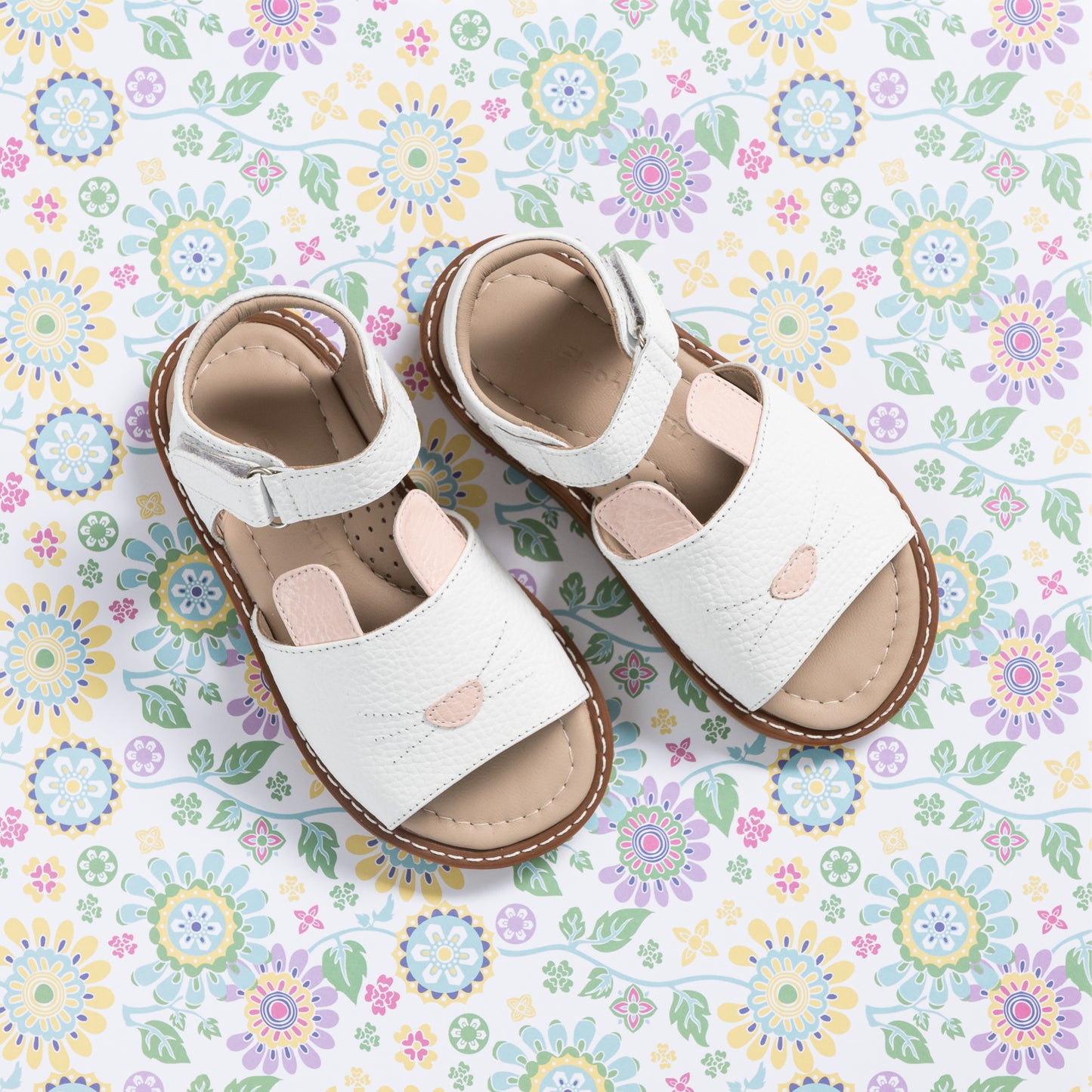 White toddler sandals with bunny face design and pink nose detail on front straps.
