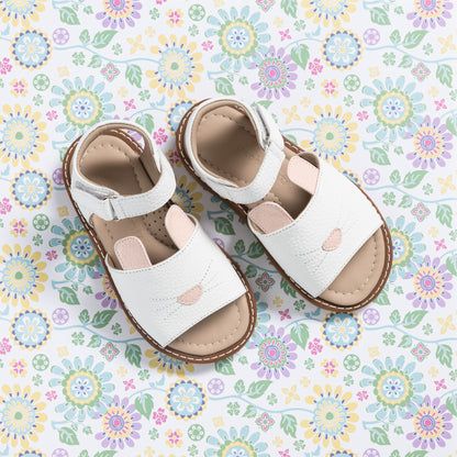 White toddler sandals with bunny face design and pink nose detail on front straps.