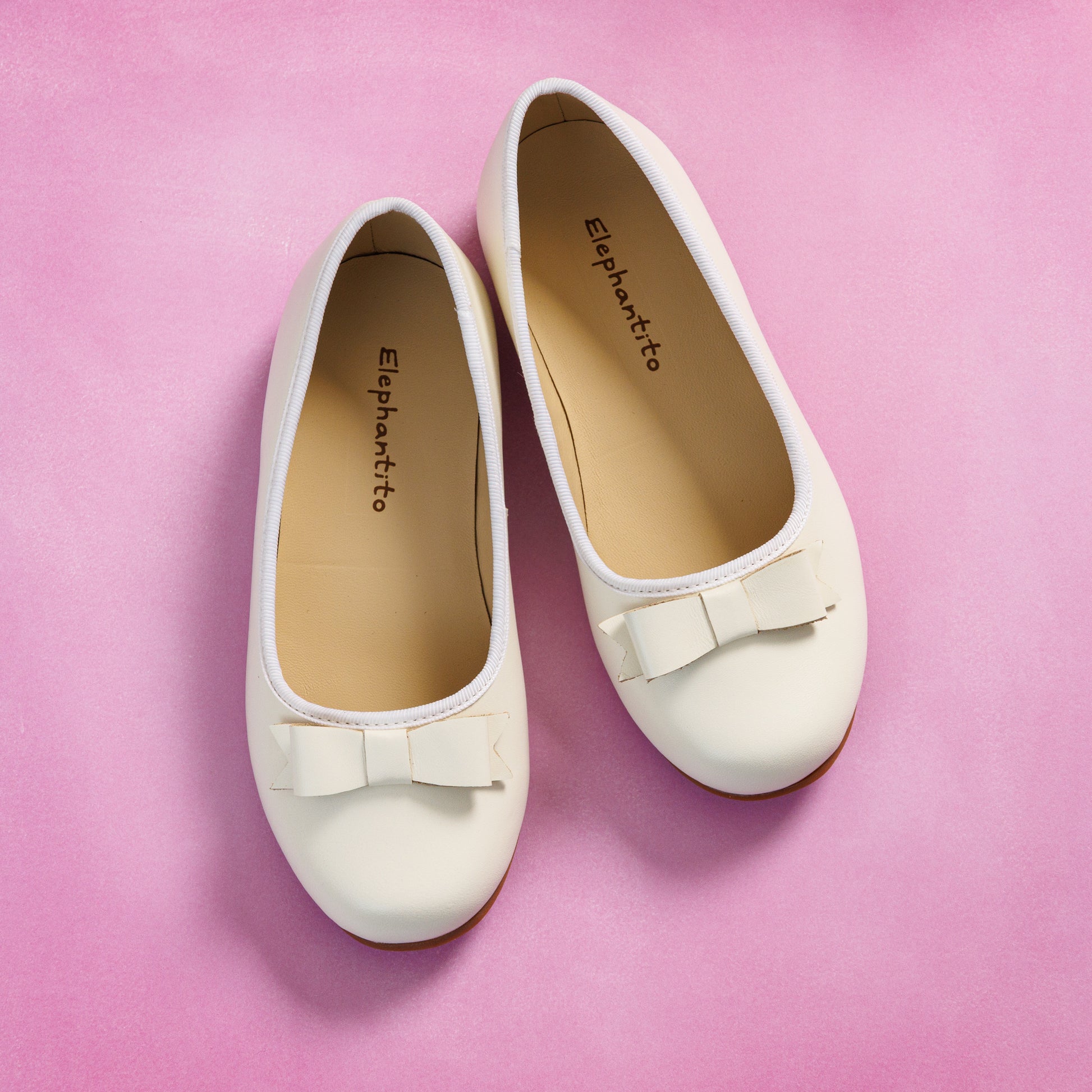 Elephantito - Bone-colored girls' ballet flats with rounded toes and small decorative bows on top.