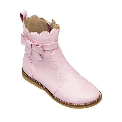 Glossy light pink toddler bootie with scalloped top edge, side bow, and tan sole.
