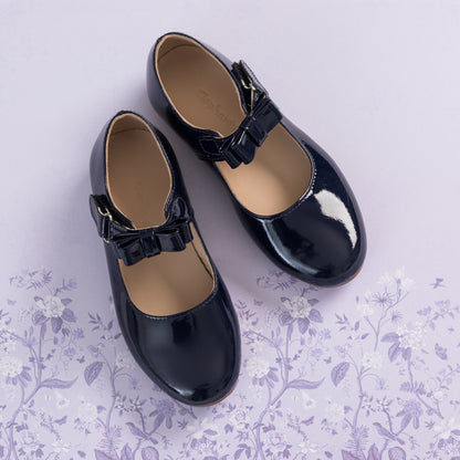 Glossy navy blue leather Mary Jane shoes with bow detail and buckle strap for girls.