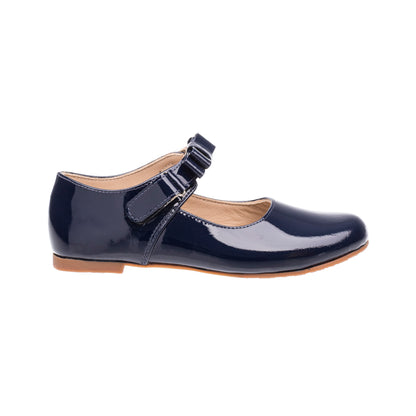 Navy blue patent leather girls Mary Jane shoe with buckle strap and tan sole.