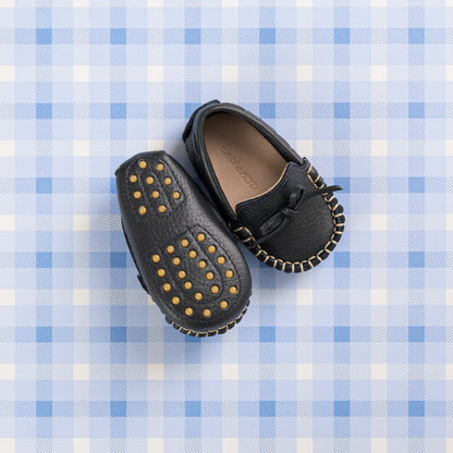 Navy blue baby driver loafers with gold studded soles and stitched detailing.