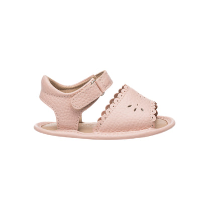 Pink toddler sandal with scalloped edge and perforated floral design, adjustable Velcro strap.