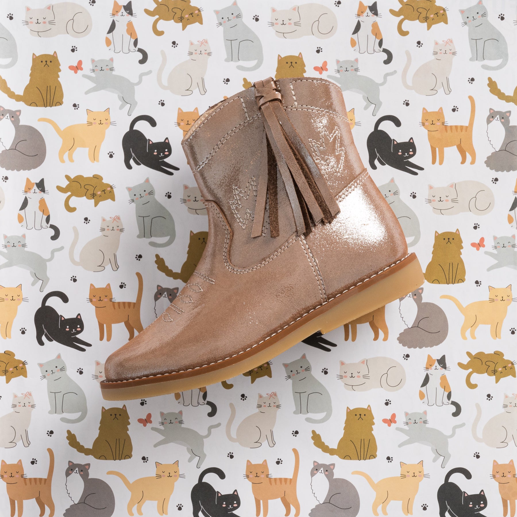 Metallic blush toddler suede boot with side zipper and tassel detail, rugged sole.