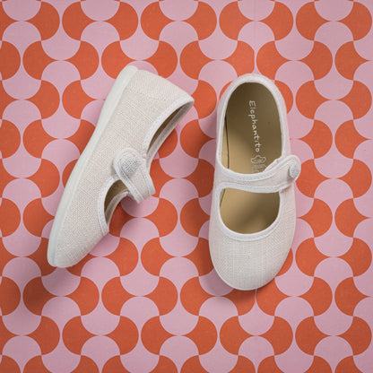 White linen Mary Jane toddler shoes with adjustable hook-and-loop strap and rounded toe.