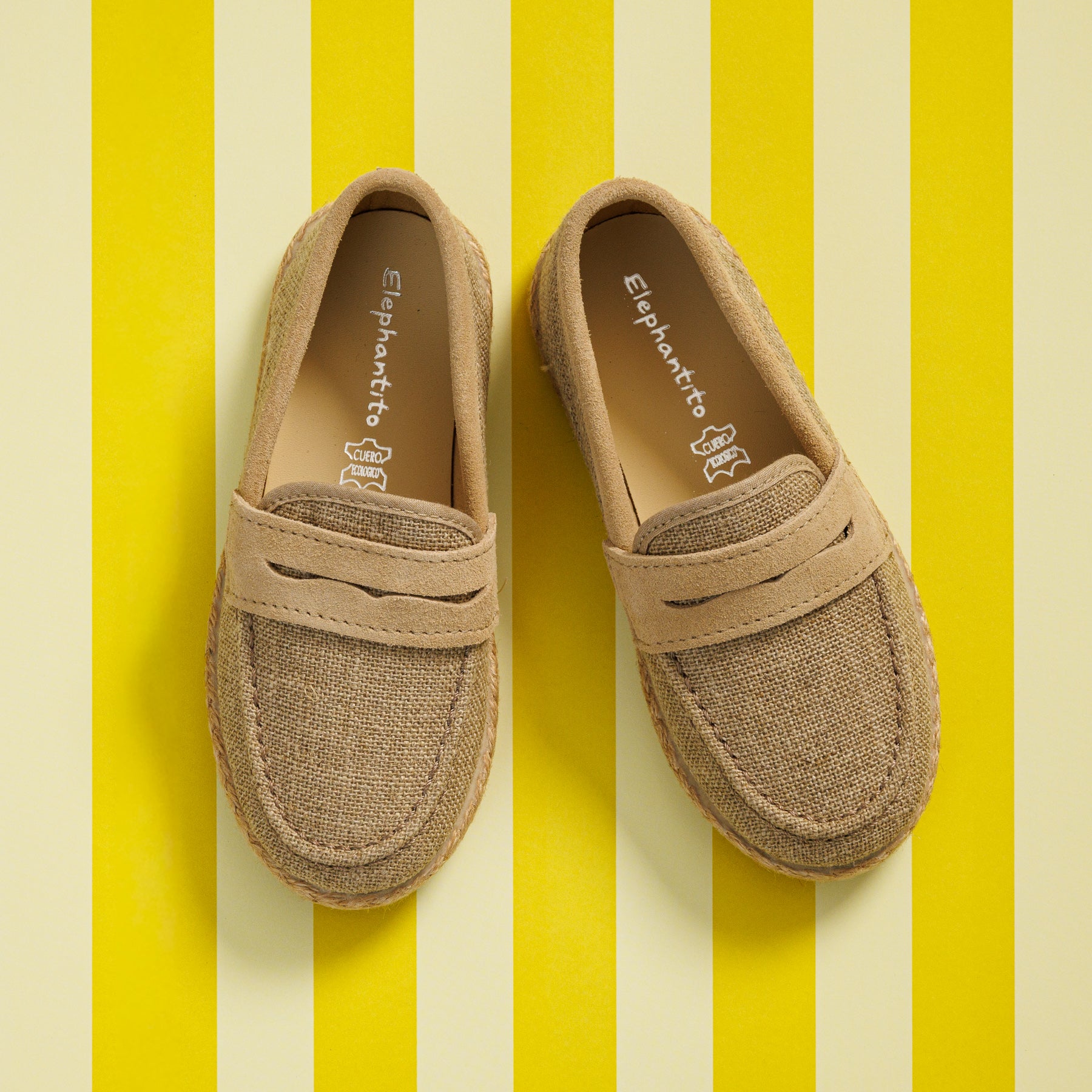 Elephantito - Beige boys loafer espadrilles with stitched detailing and textured fabric upper on yellow striped background.