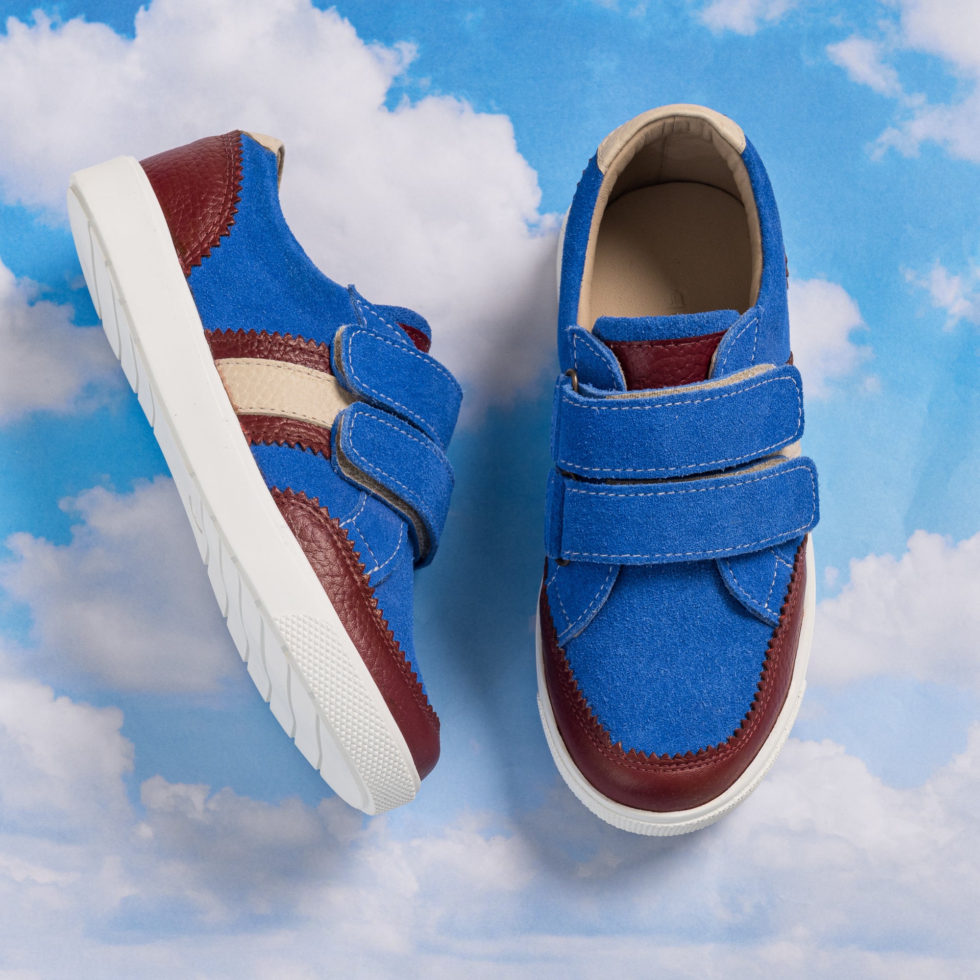 Blue denim boys sneaker with maroon accents, white sole, and dual velcro straps.