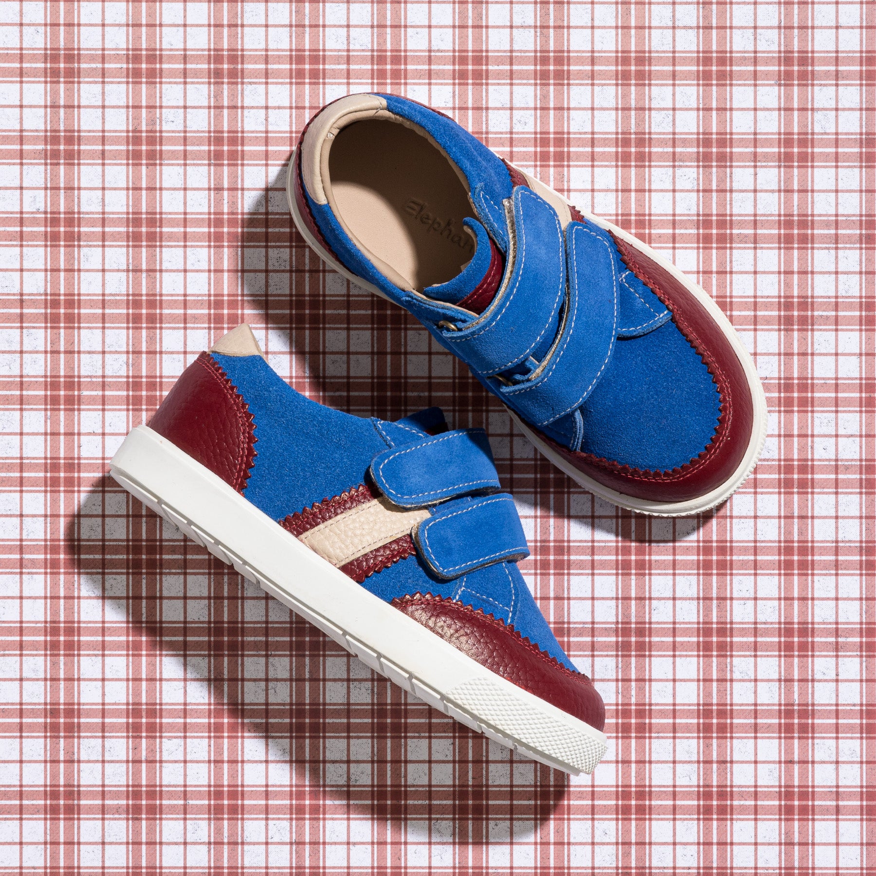 Blue denim toddler sneaker with maroon toe and heel, white sole, and double Velcro straps.