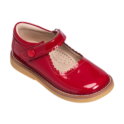 Red patent leather Mary Jane shoe with scalloped edge and velcro strap, tan sole.
