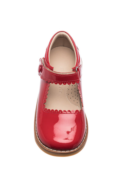 Shiny red patent leather Mary Jane with scalloped edges and buckle strap on tan sole.
