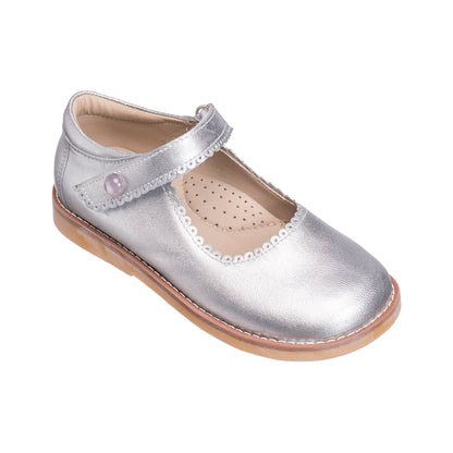 Silver leather Mary Jane shoe with scalloped edge and Velcro strap on tan sole.