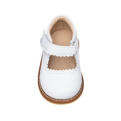 White toddler Mary Jane shoe with scalloped edges and a tan sole.
