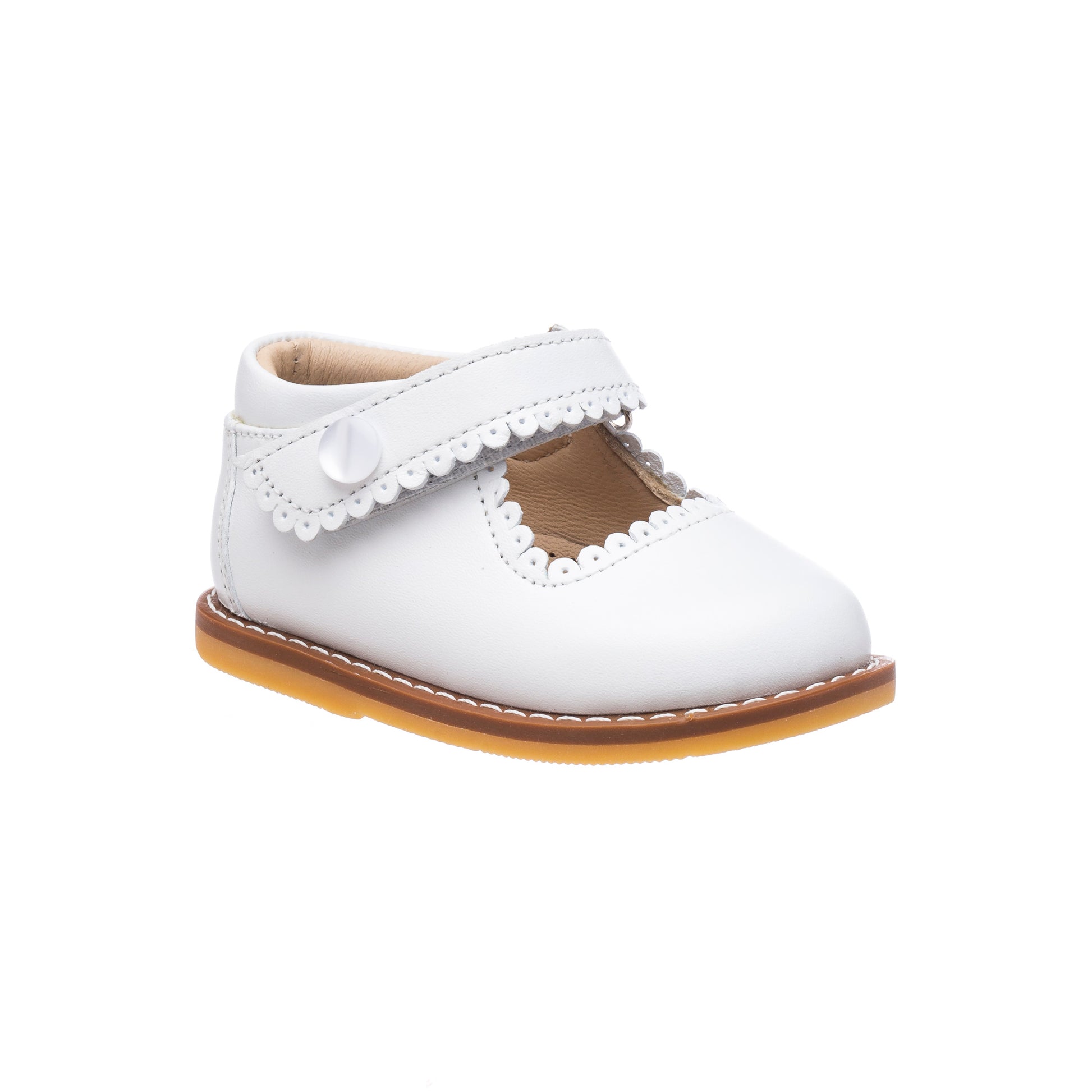 White toddler Mary Jane shoe with scalloped edges, hook-and-loop strap, and tan sole.