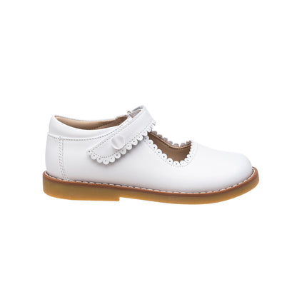 White leather Mary Jane shoe for girls with scalloped edge strap and tan sole.