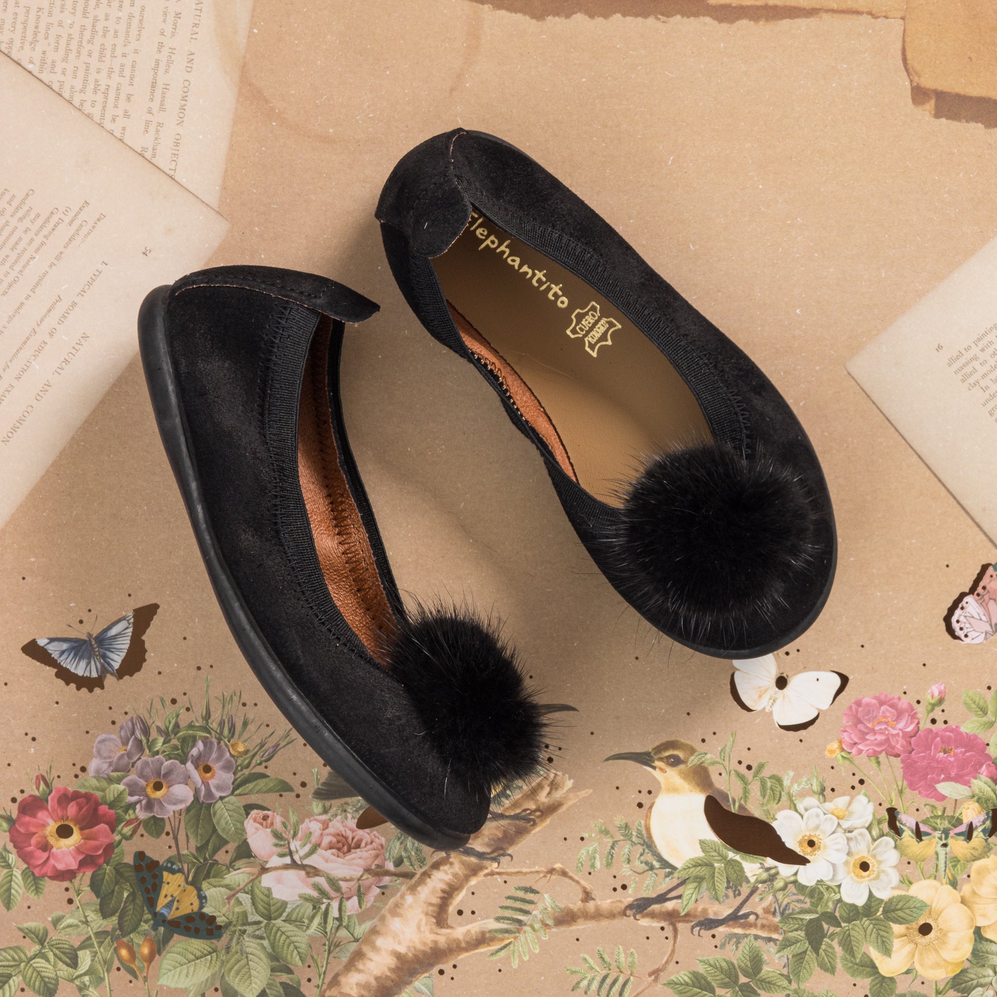 Black suede ballerina shoes for children with large black pom pom on toe.
