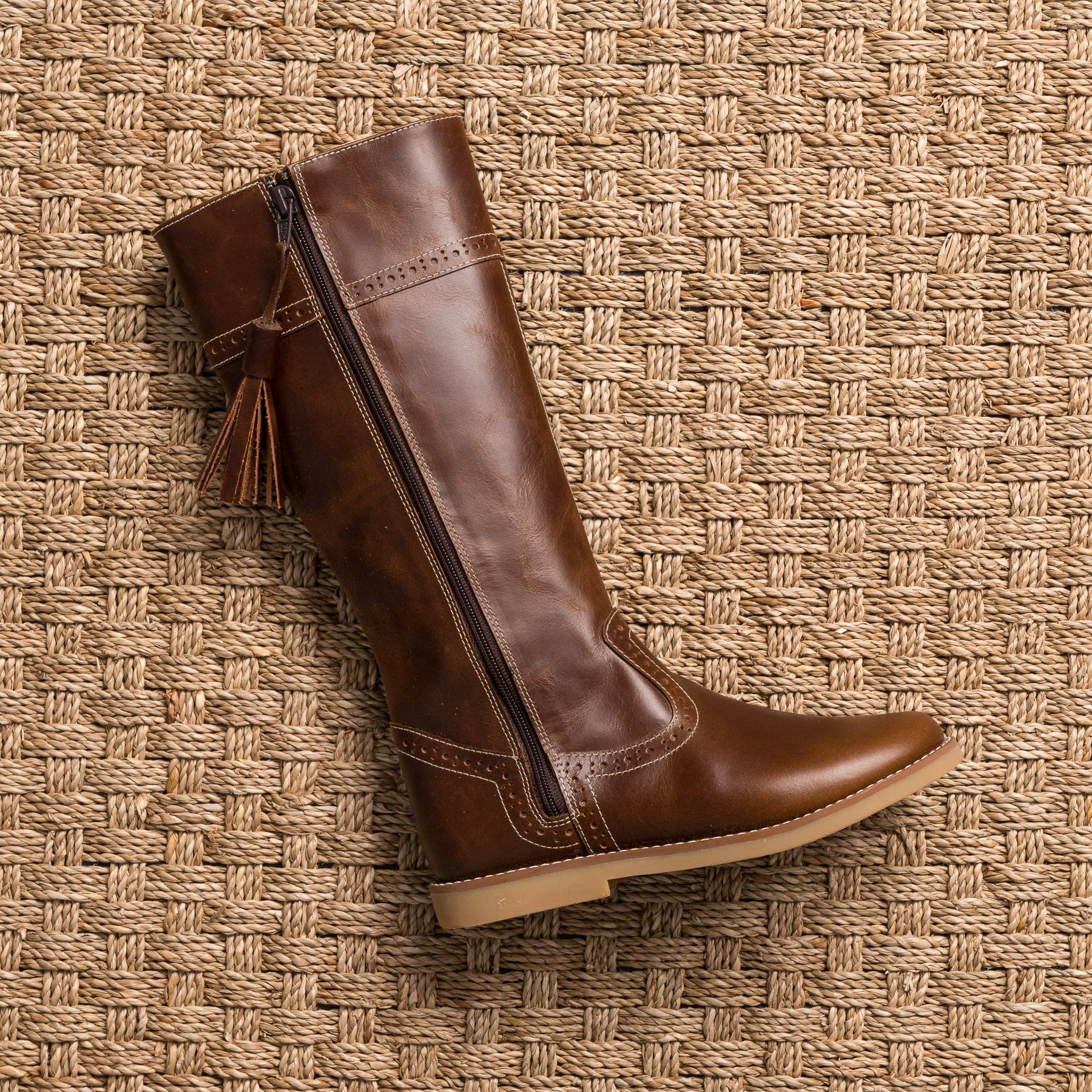 Brown leather toddler riding boot with side zipper and tassel detail.