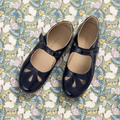 Navy blue patent leather Mary Jane shoes with teardrop cutouts and adjustable strap.