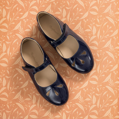 Navy blue patent leather Mary Jane shoes with cut-out teardrop details and adjustable straps for girls.