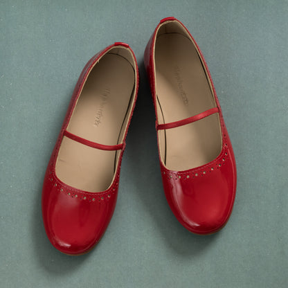 Red patent leather ballerina flats with single elastic strap and rounded toe for girls.
