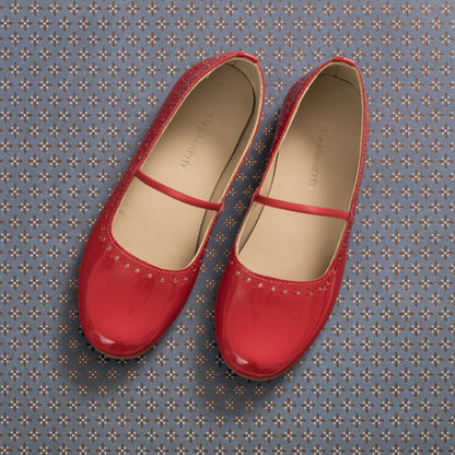 Red patent leather ballerina flats with a thin strap and perforated detailing around the toe.
