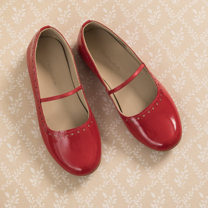 Red patent leather ballerina flats for girls with a thin strap and perforated detailing near the toe.