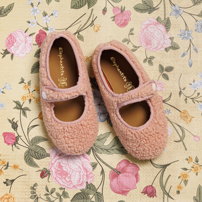 Pink shearling Mary Jane shoes for toddlers with strap and rounded toe on floral background.