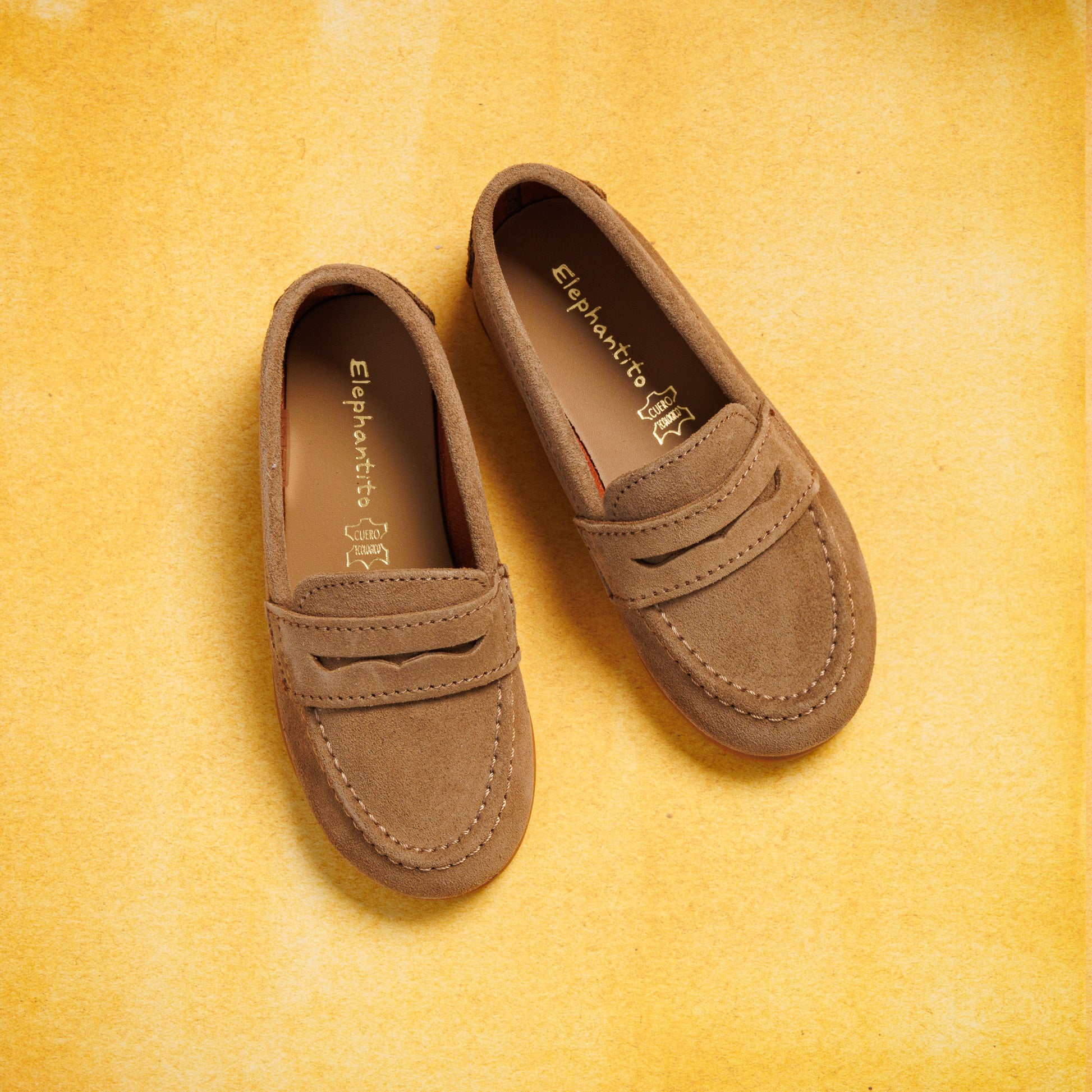 Toffee brown suede boys penny loafers with moccasin stitching and a classic slip-on design.