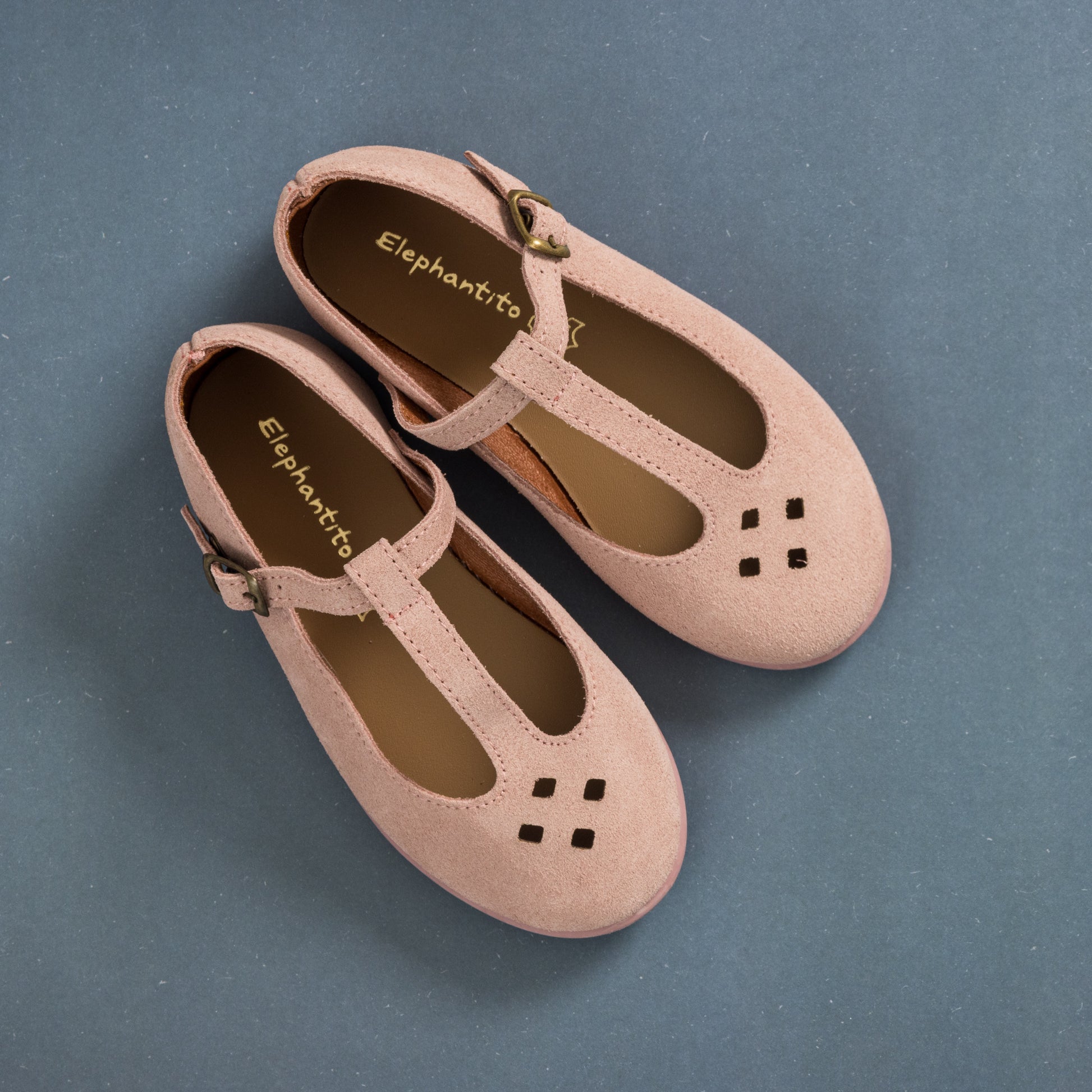 Pink suede T-bar toddler shoes with cutout details and adjustable buckle straps.