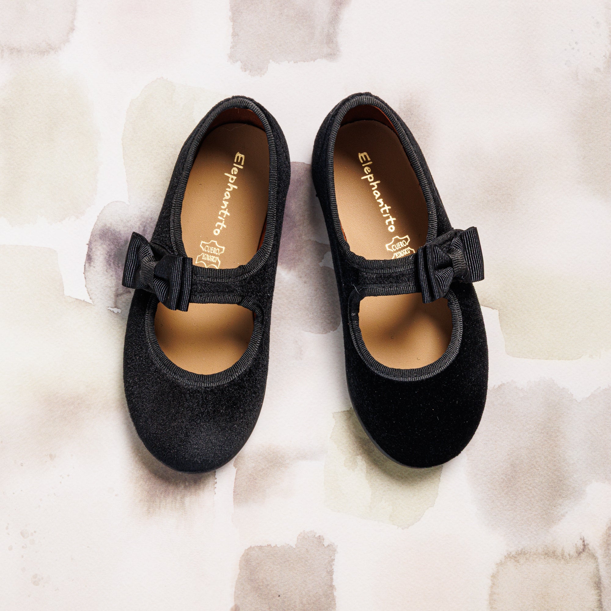 Black velvet Mary Jane shoes for girls with a bow detail and tan insoles.