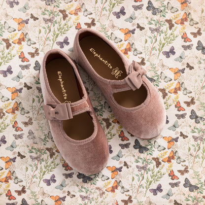 Pink velvet Mary Jane shoes for toddlers with a bow on the strap and rounded toes.