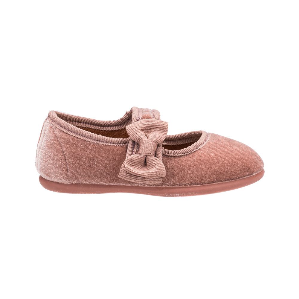 Pink velvet Mary Jane shoe with a large bow on the side and a soft sole.