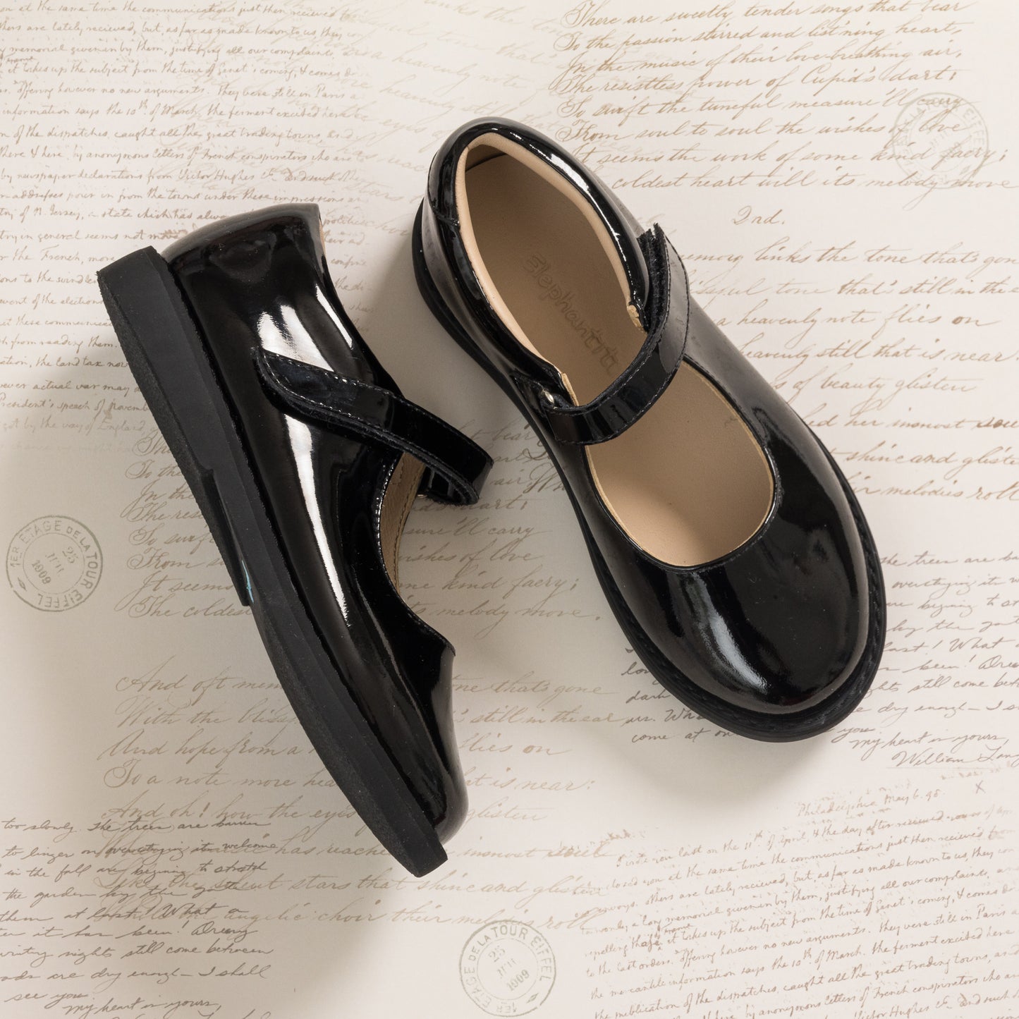 Black patent leather girls Mary Jane shoes with velcro strap and rounded toe.