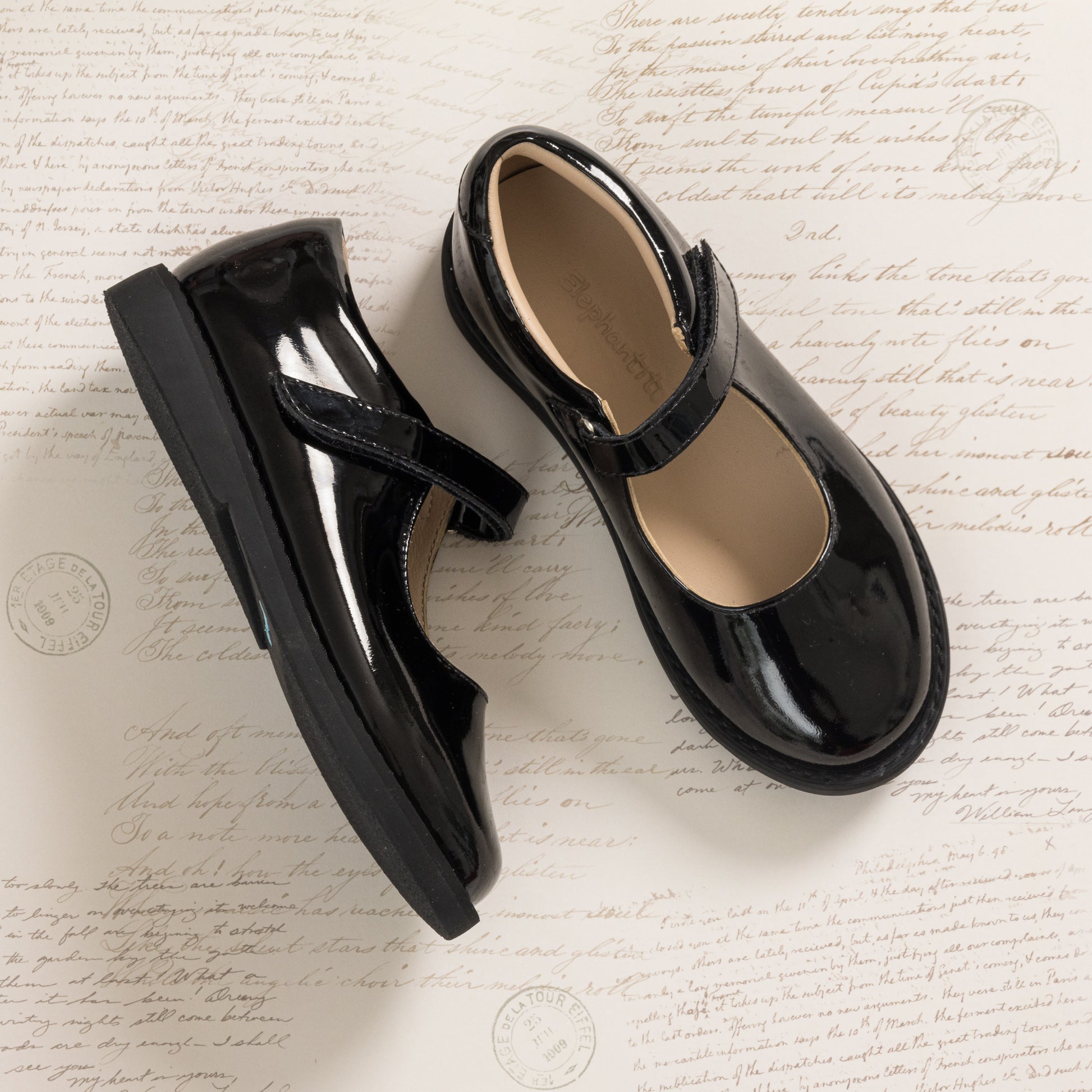 Black patent leather girls Mary Jane shoes with velcro strap and rounded toe.