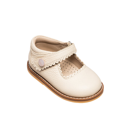 Cream toddler Mary Jane shoe with scalloped edge strap and heart-shaped button detail.