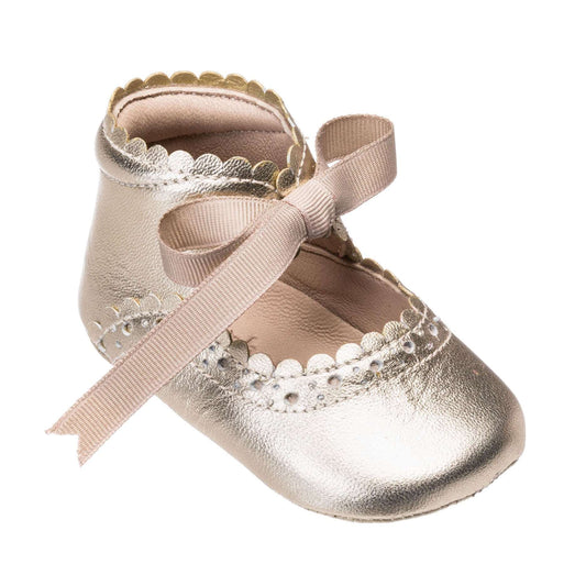 Metallic gold baby shoe with scalloped edges and a pink ribbon bow on top.