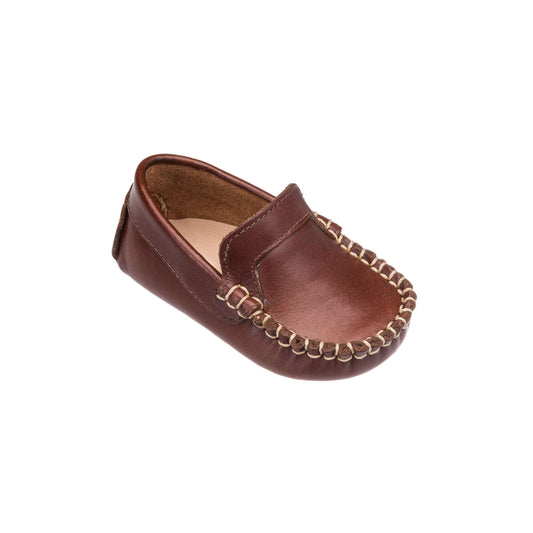 Brown leather baby moccasin with beige whipstitching along the toe and soft sole.