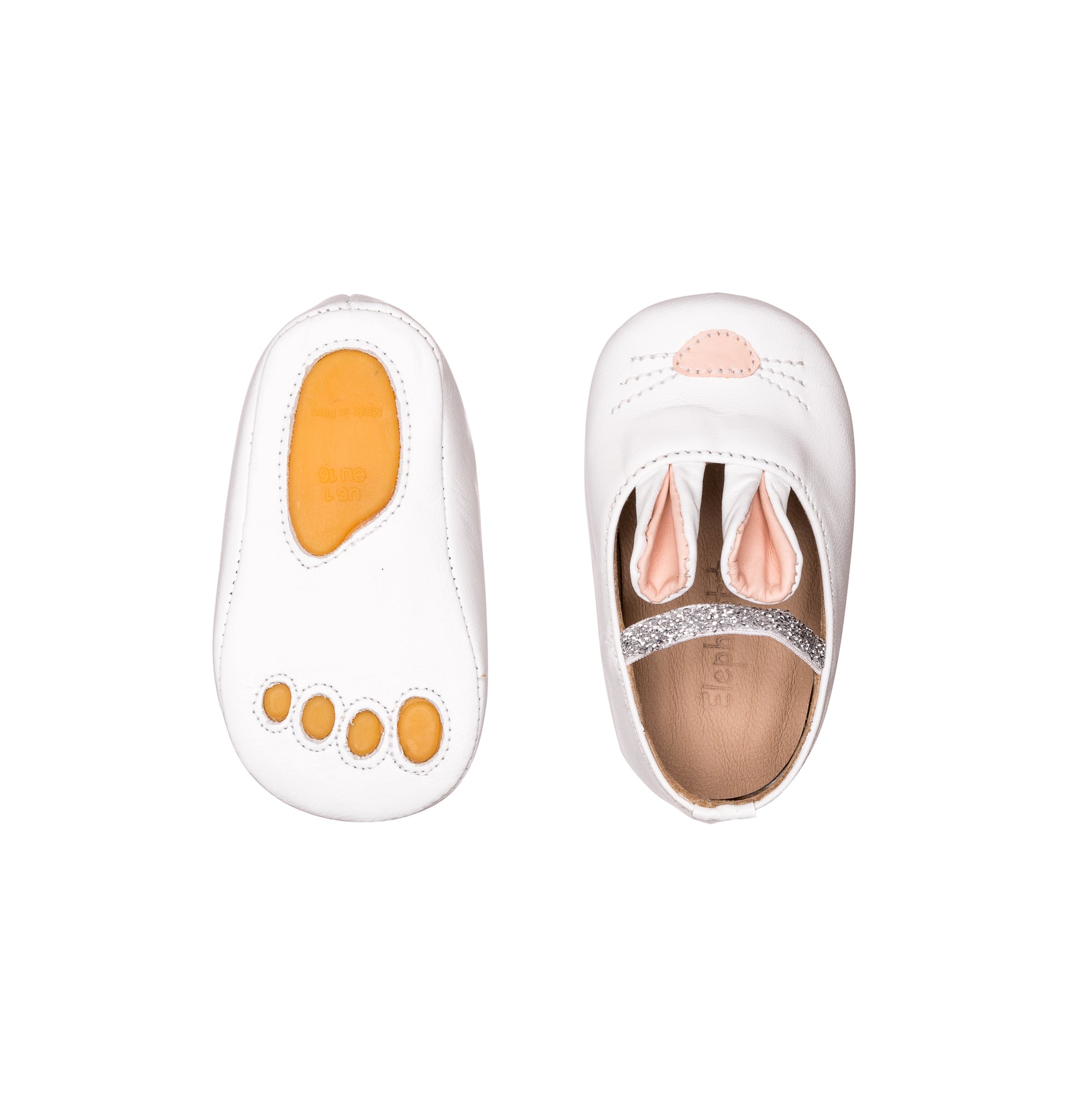 White baby slipper with bunny ears and pink nose detail, soft sole with paw prints.
