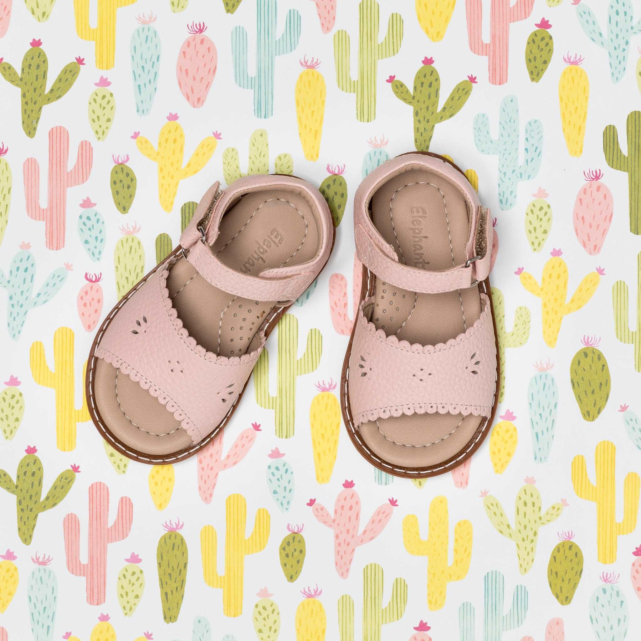 Pink toddler sandals with scalloped edges and perforated flower details, soft leather straps.