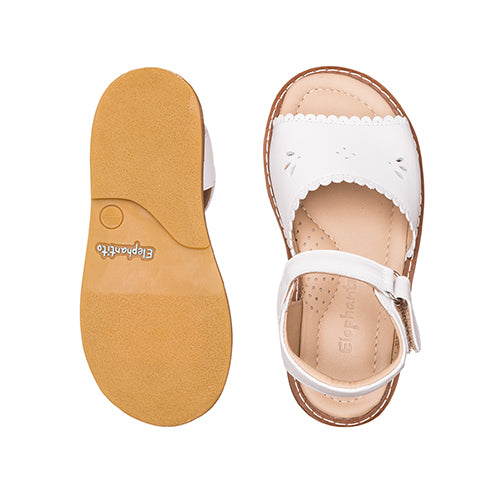 White leather children's sandal with scalloped edges and ankle strap, tan sole with grip texture.