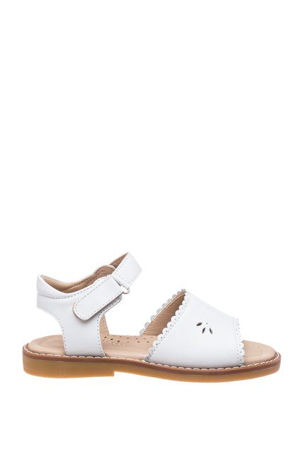White toddler sandal with scalloped edges and perforated flower detail, adjustable ankle strap, tan sole.