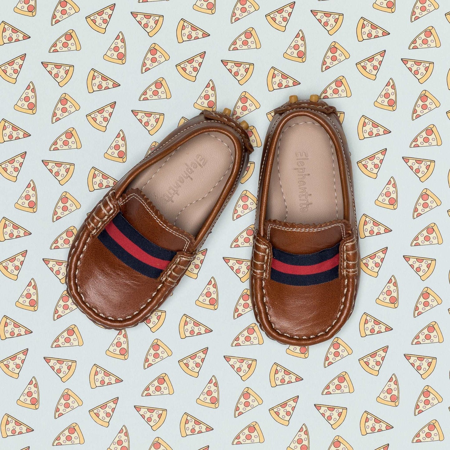 Natural brown toddler loafers with red and navy striped fabric detail and stitched edges.