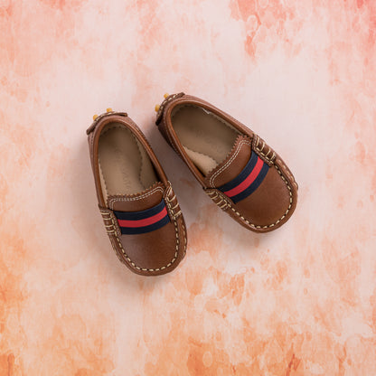 Natural brown toddler loafers with striped red and navy fabric detail and stitched moc toe.