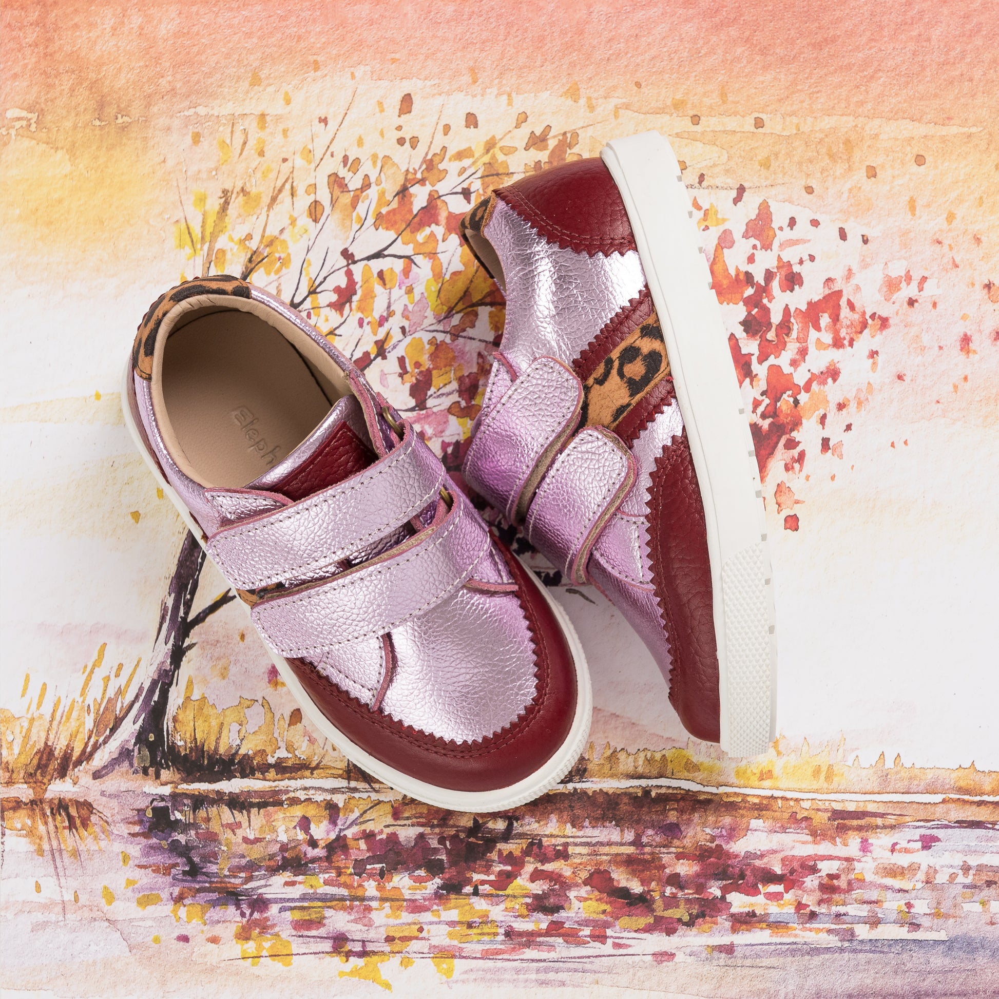 Metallic carnation pink girls' sneakers with double velcro straps and white soles.