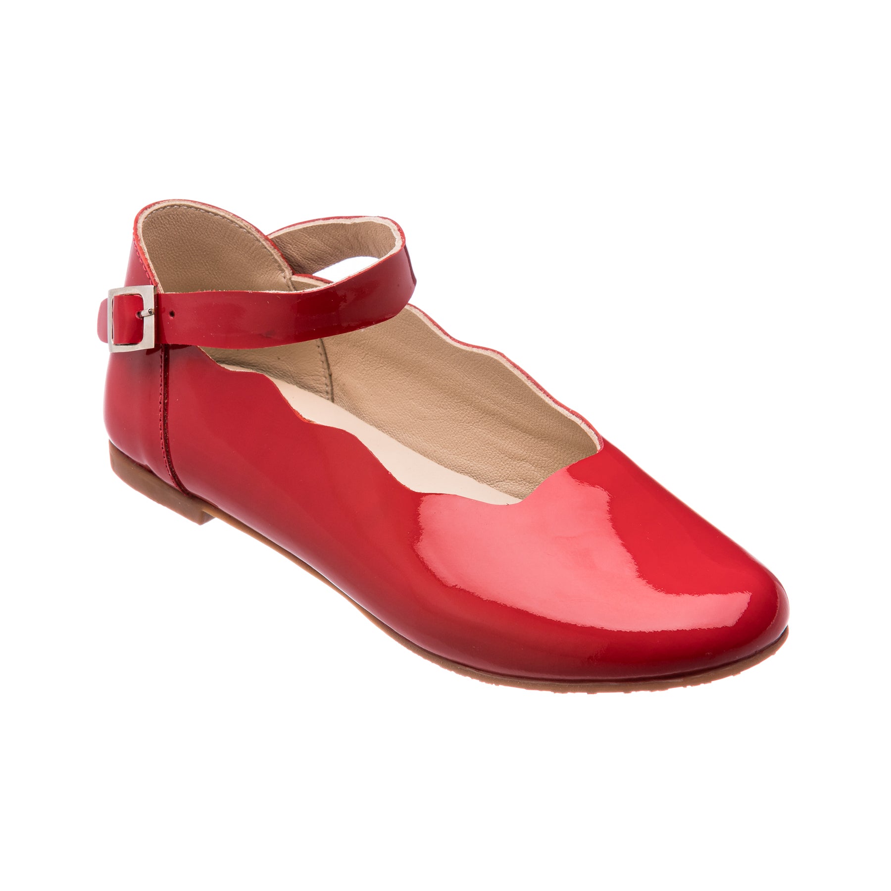 Glossy red patent leather girl’s flat with scalloped edge and ankle strap buckle closure.